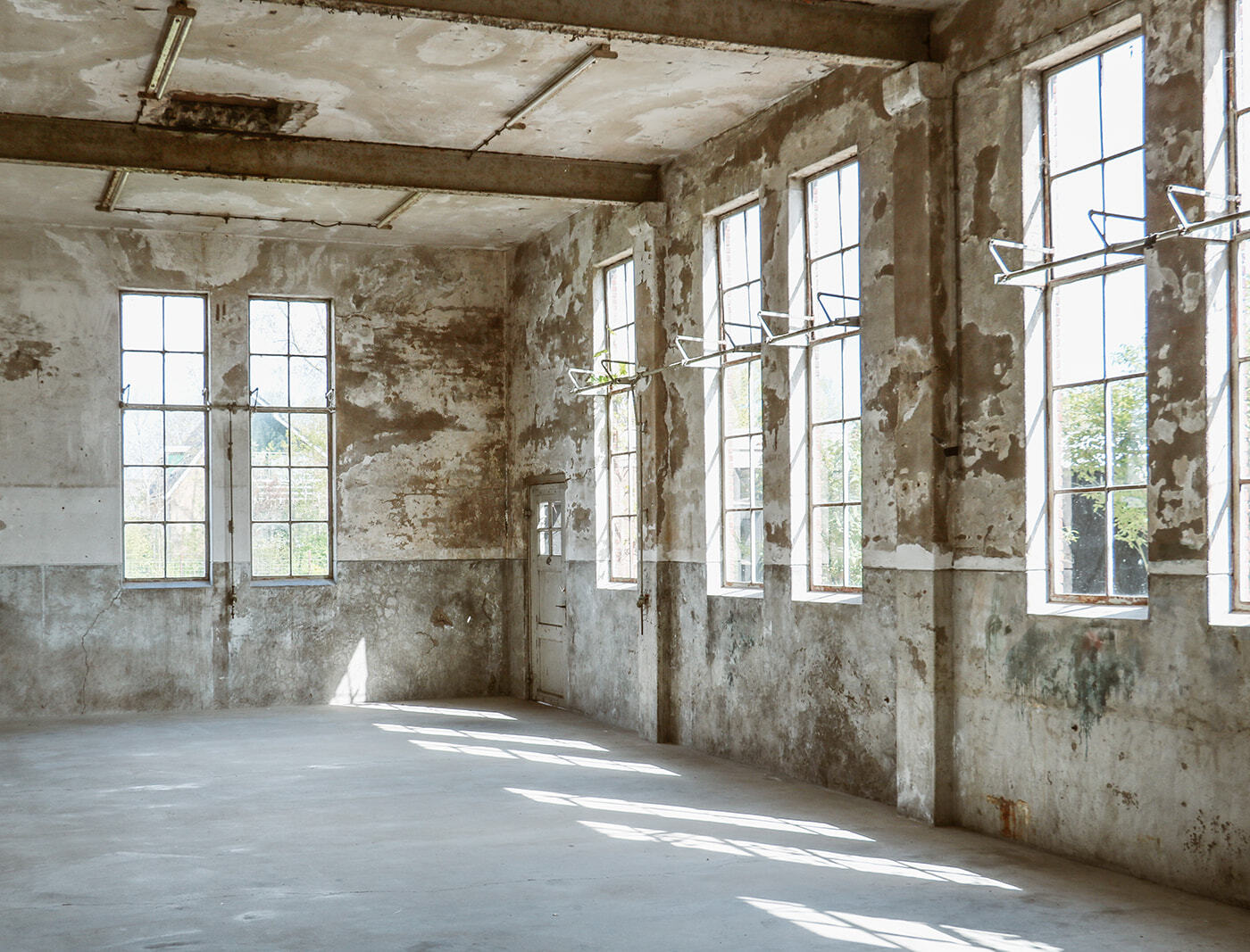 Interieur daglichtstudio met betonnen vloer en stalen ramen